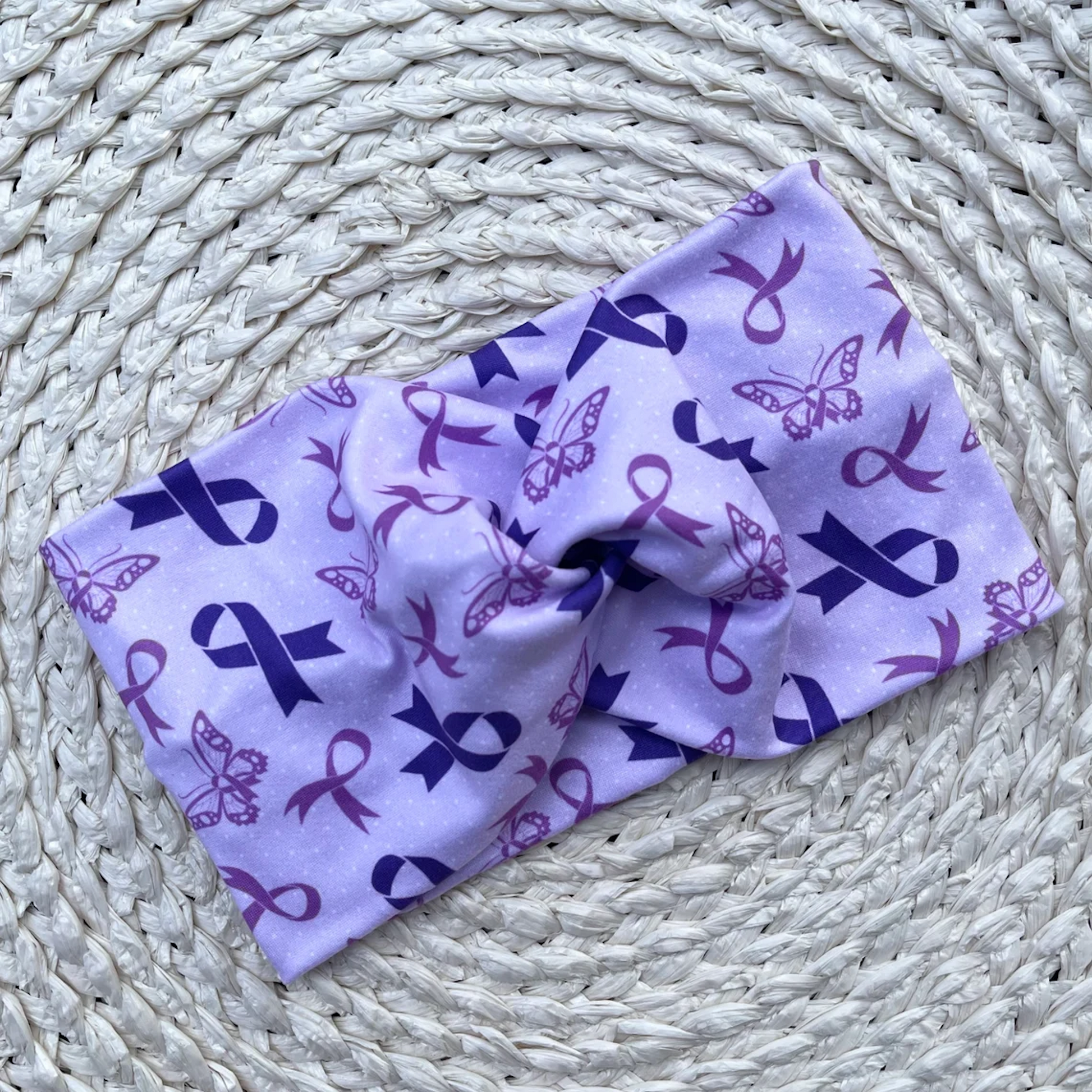 Wide, twisted headband in light purple color with purple ribbon and butterfly print.
