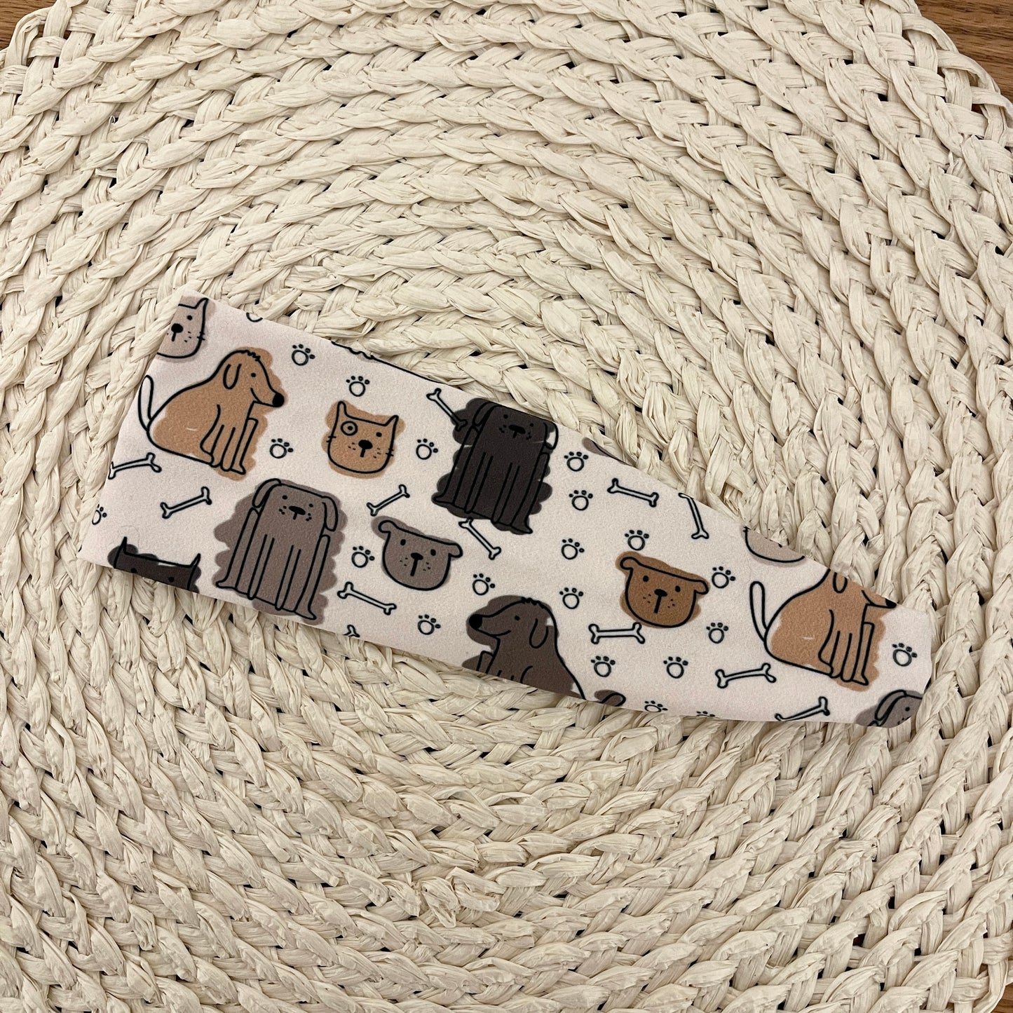Light brown, stretchy headband with dog print.