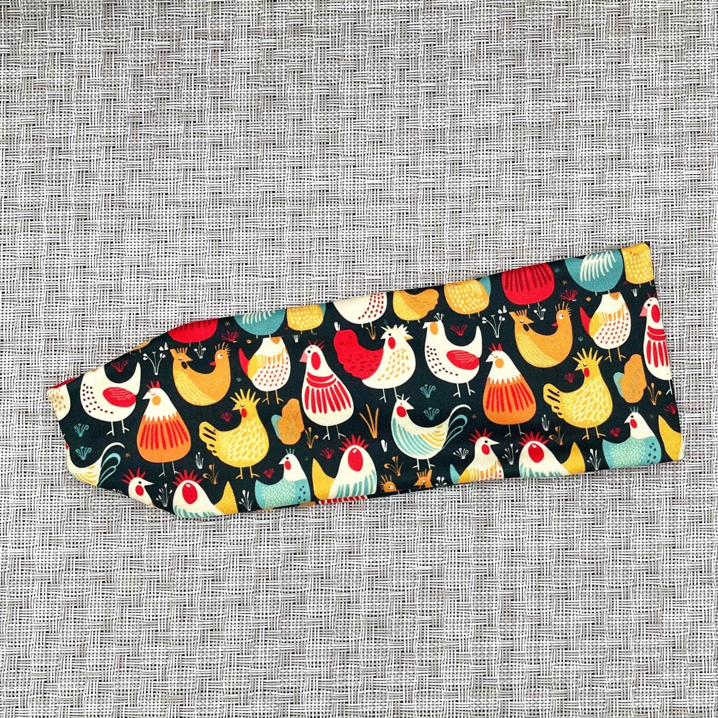 Navy blue headband with chicken print on gray background.