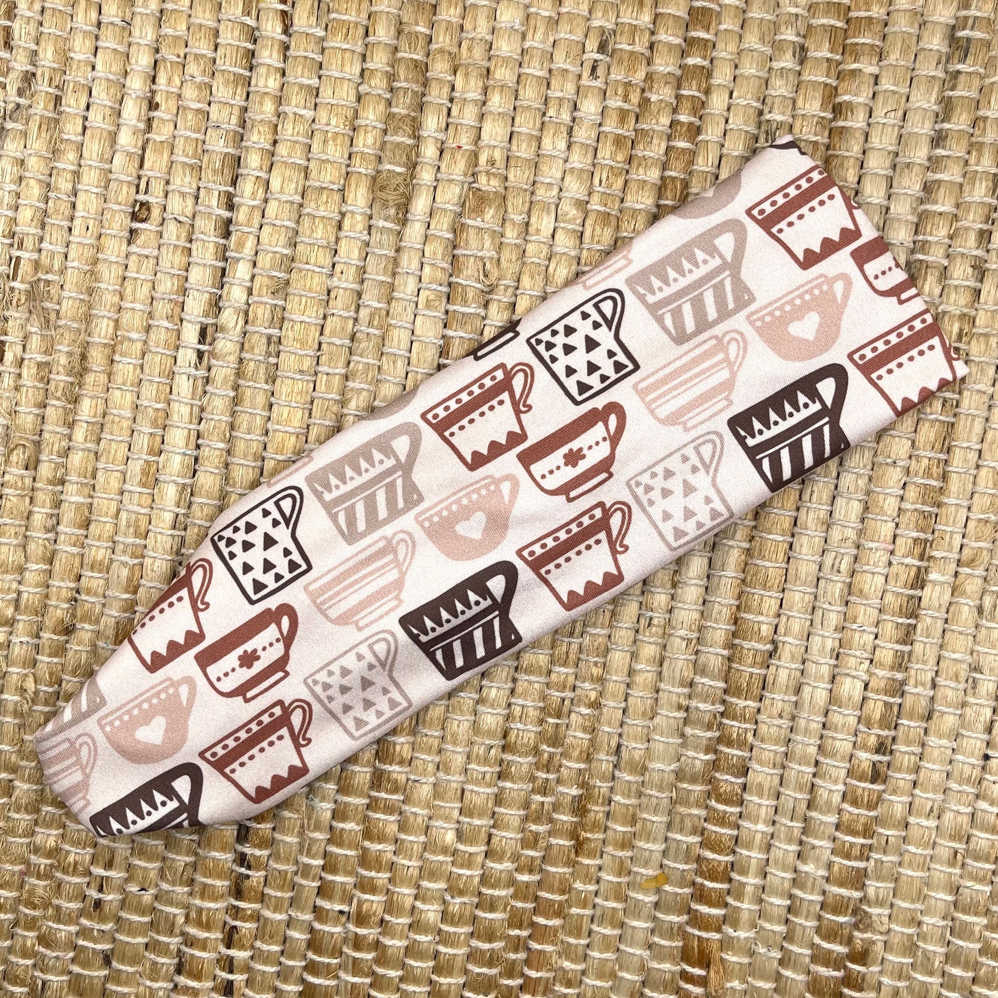 Stretchy, light brown headband with brown coffee cup print.