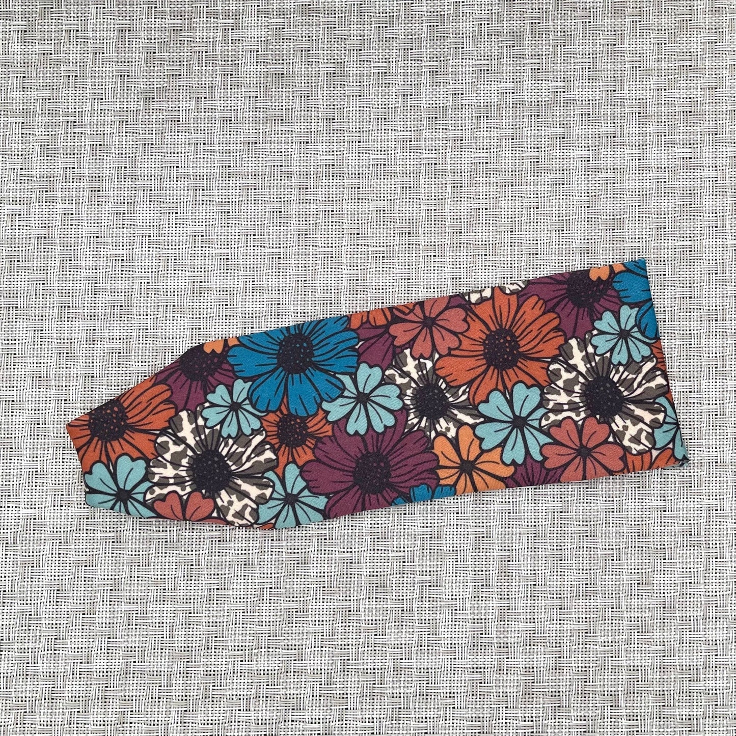 Floral patterned headband on a textured gray background