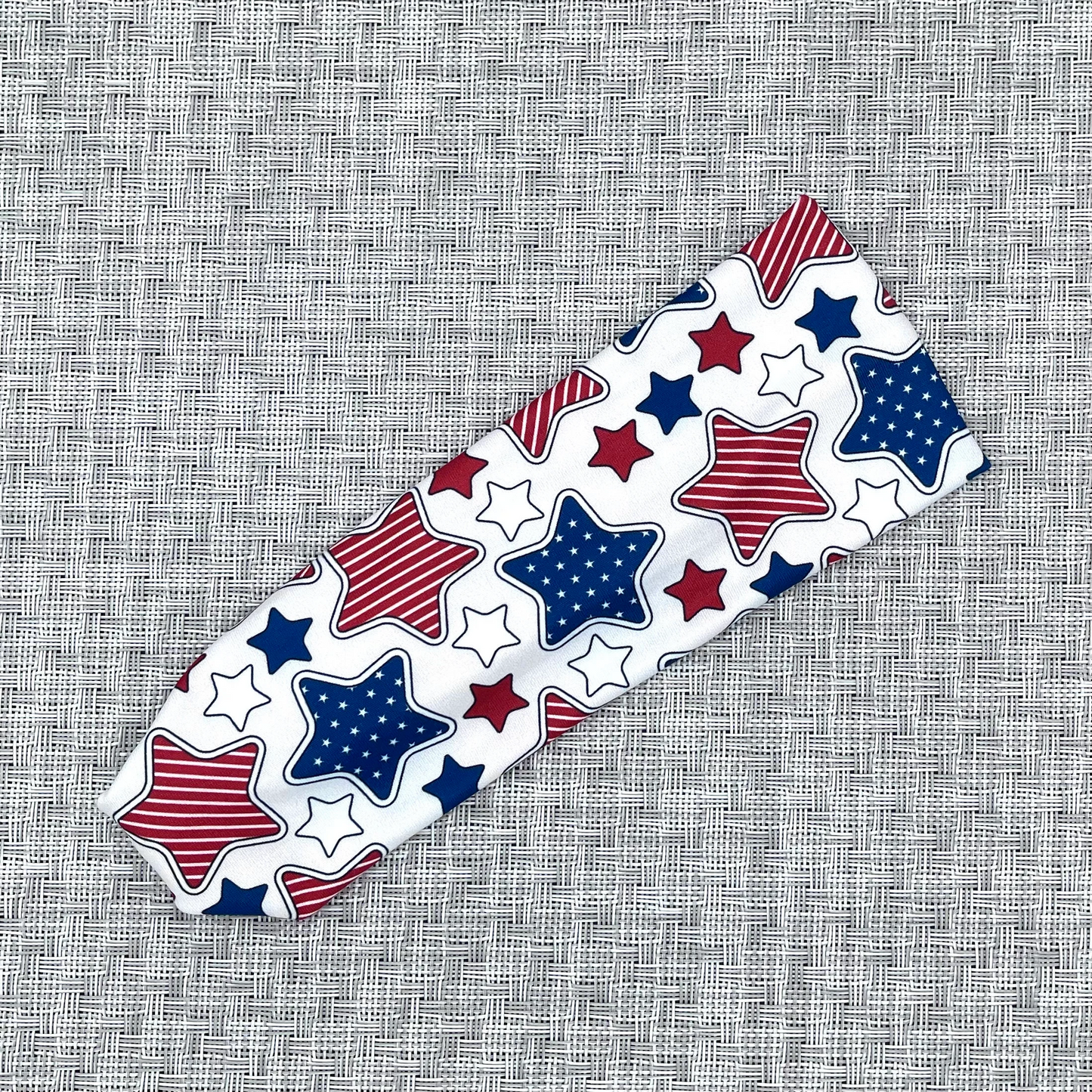 Decorative headband with red, white, and blue stars on a textured gray background