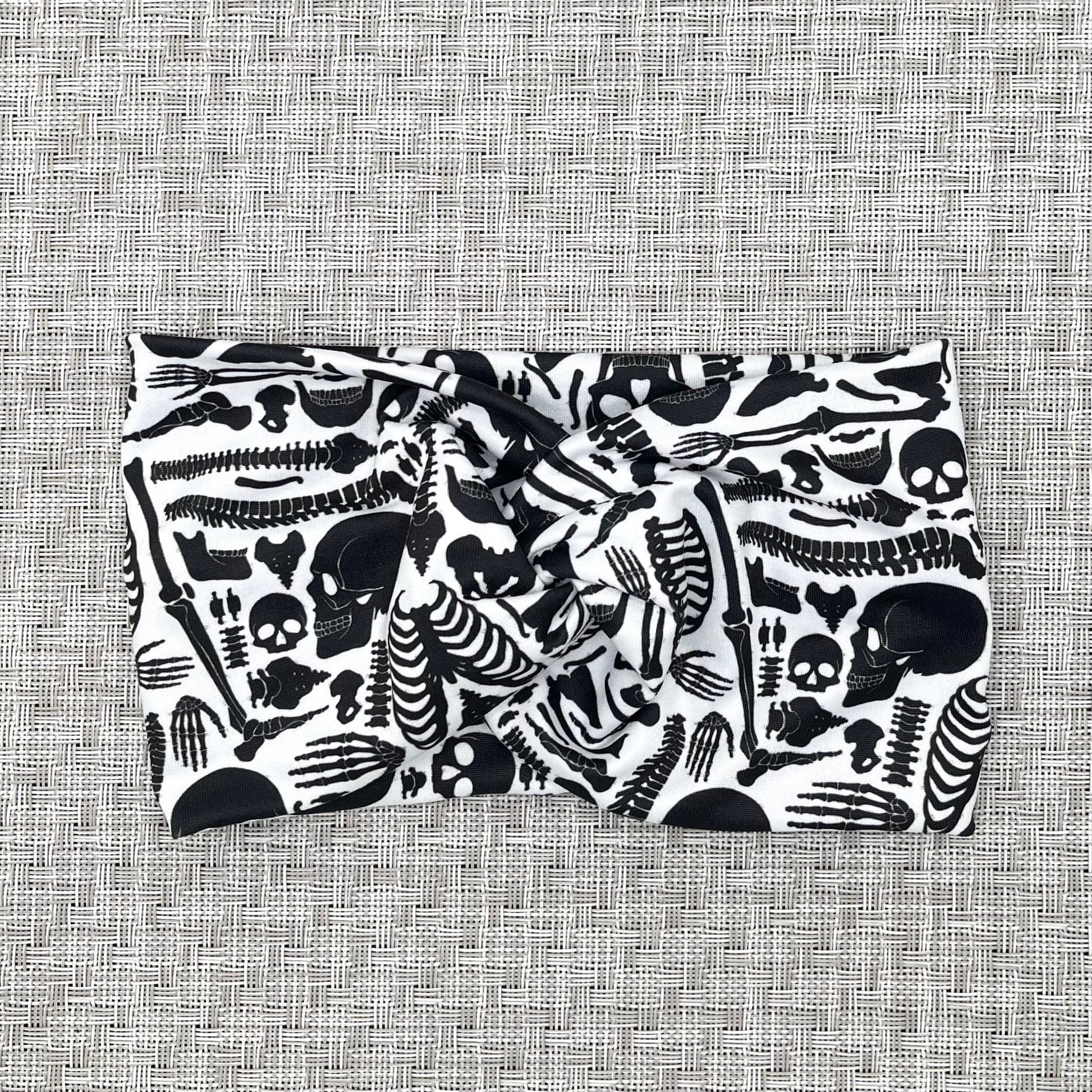 Wide twist headband with black skeleton print.
