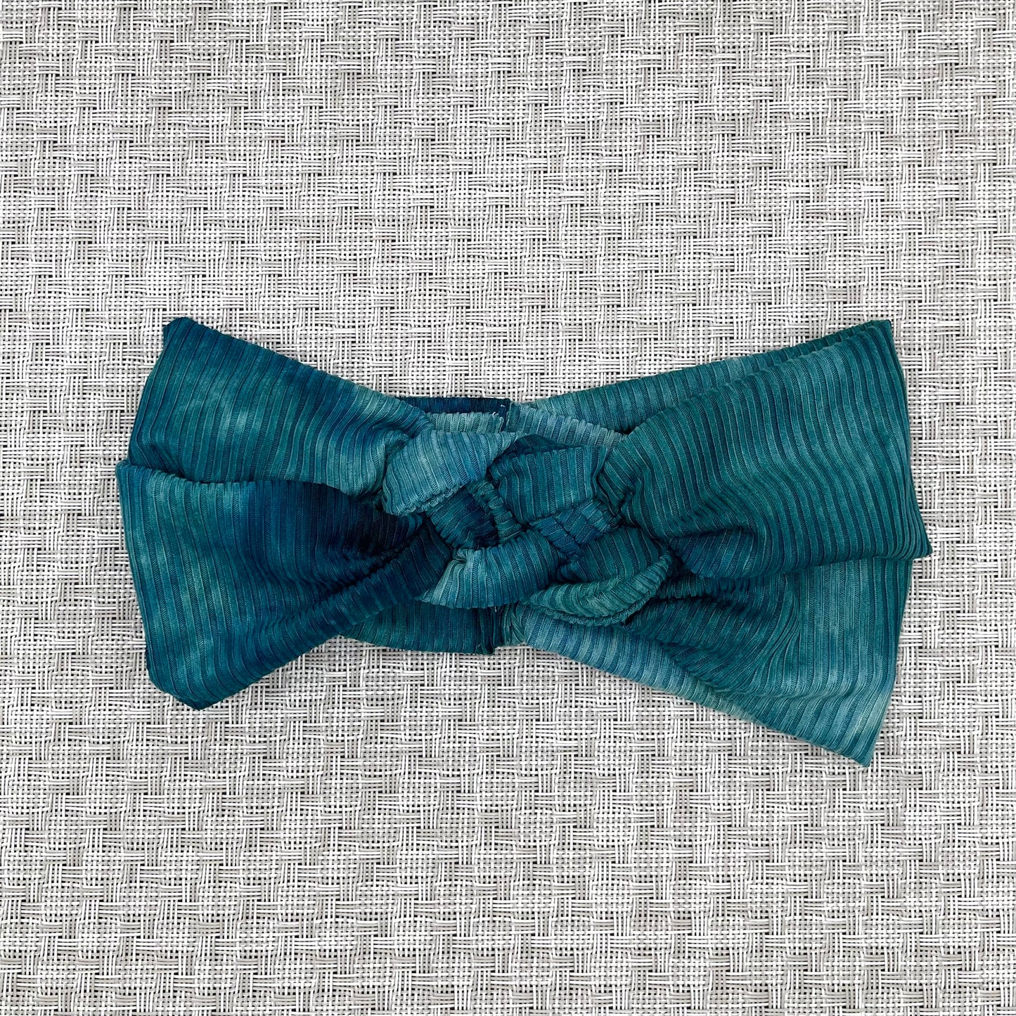 Sailot knot style headband in ribbed, teal tie dye fabric.