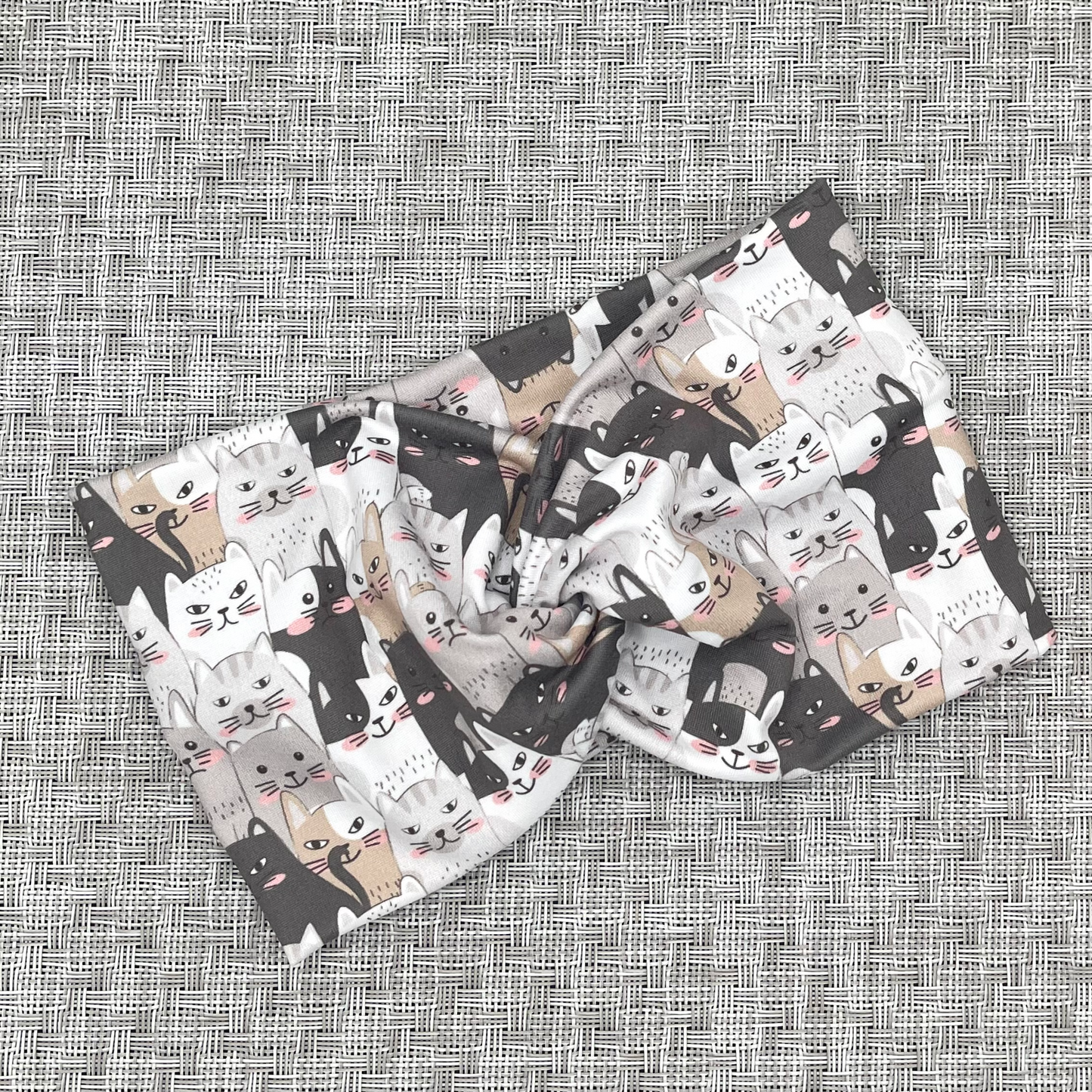 Wide, twisted headband in with gray and tan cat print.