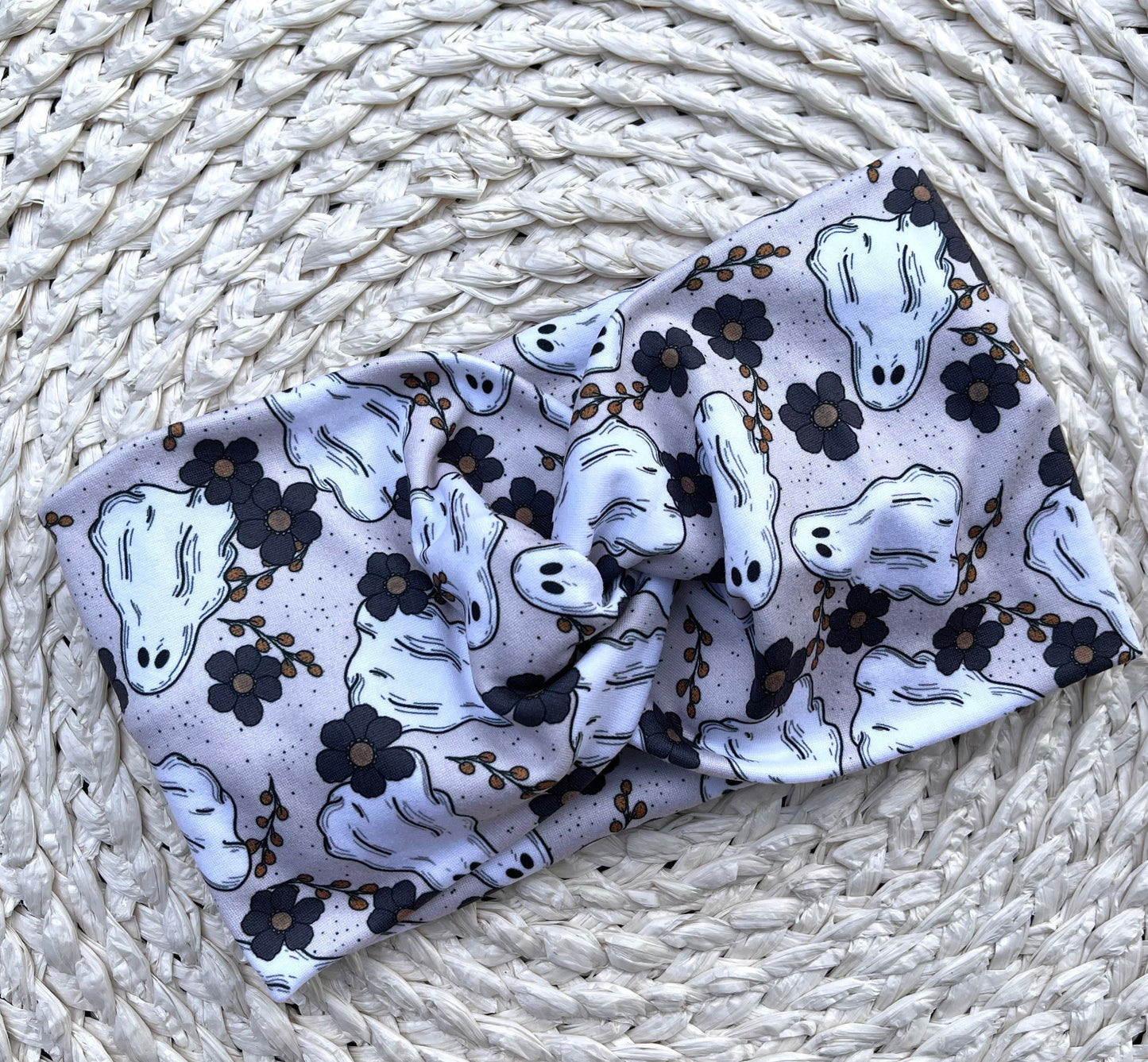 Wide, twisted headband in cream/gray with floral and ghost print.