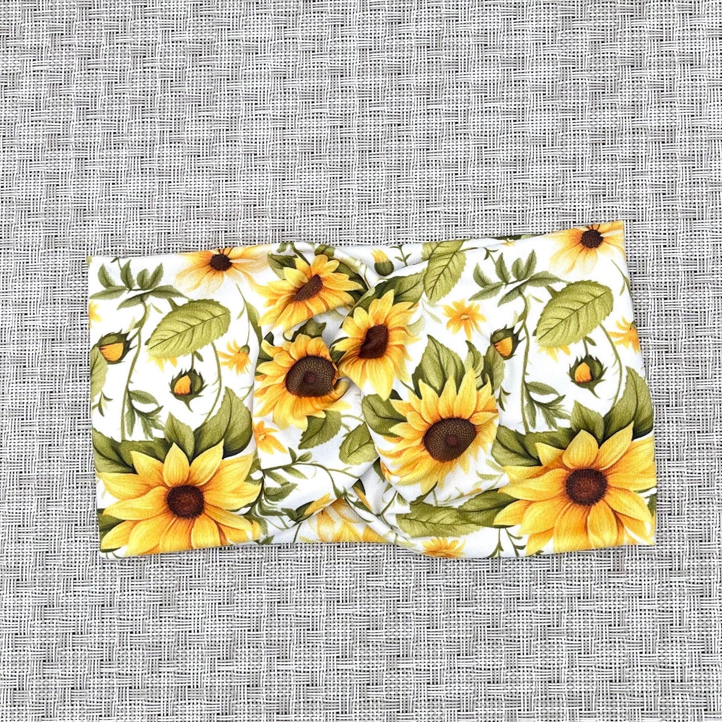 White, stretchy headband in white with yellow sunflower print.