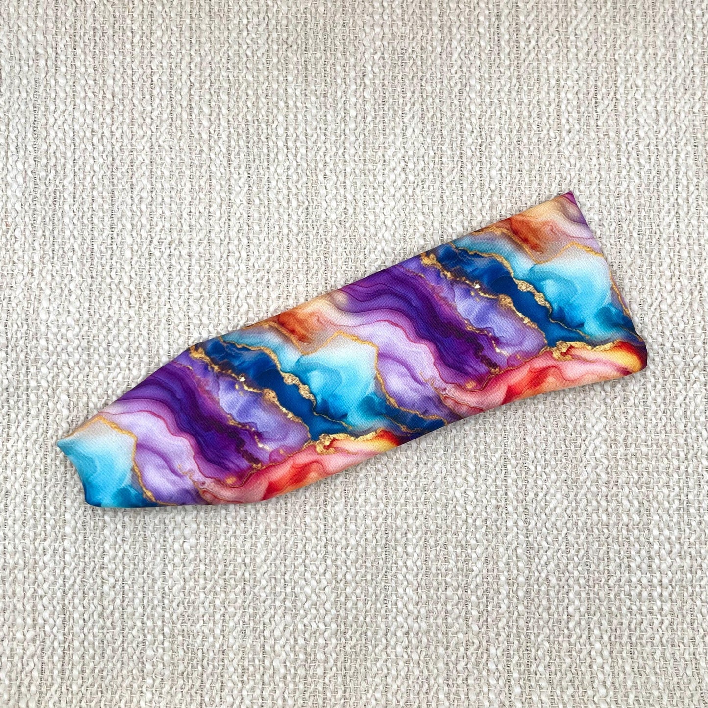 Flat, stretchy headband in multi-color watercolor print.