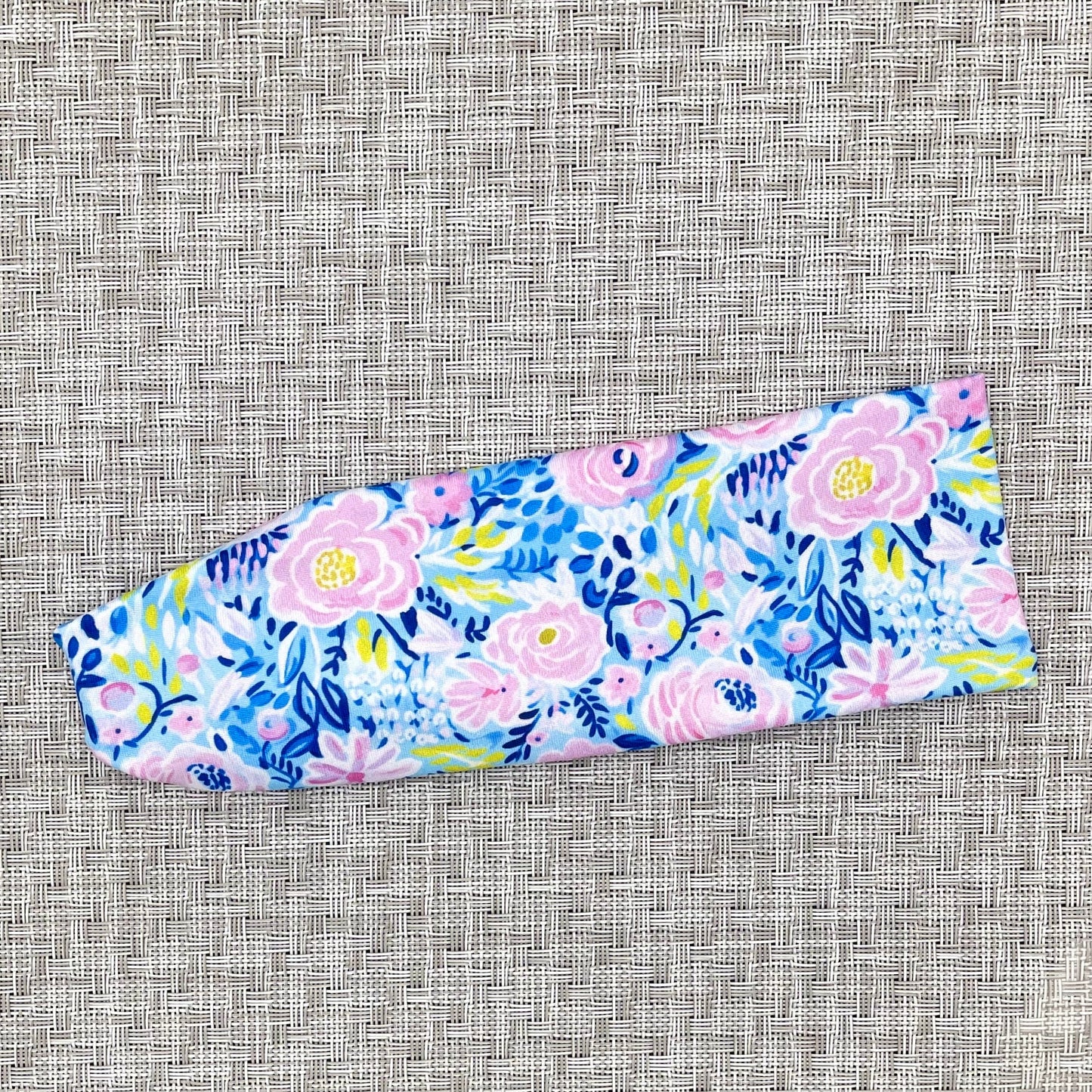 Flat, stretchy headband in bright blue and purple floral print.