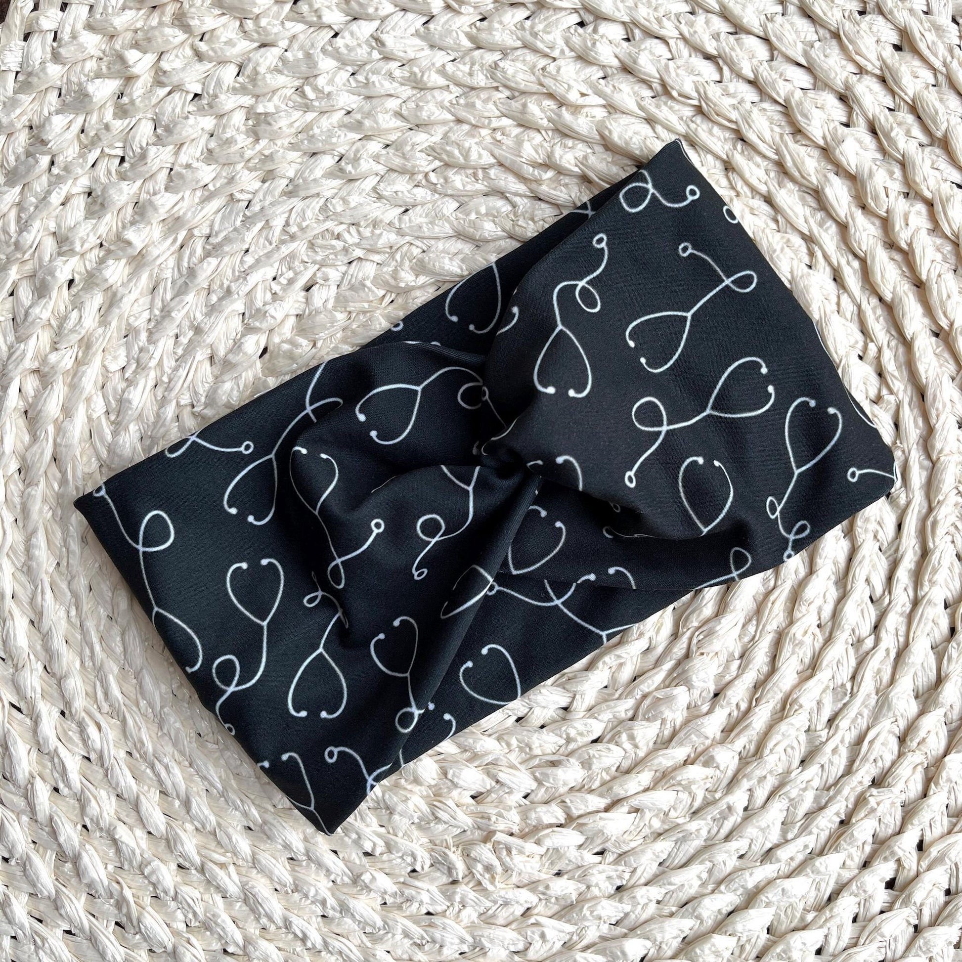 Black, wide twisted headband with white stethoscope print.