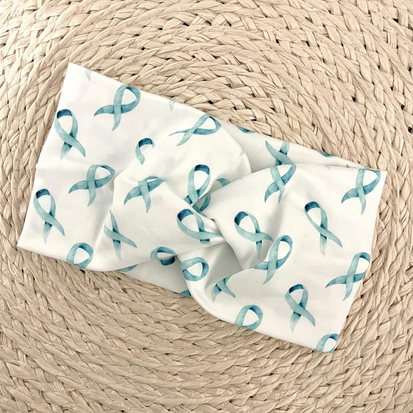 Wide, white, twisted headband with light blue ribbon print.