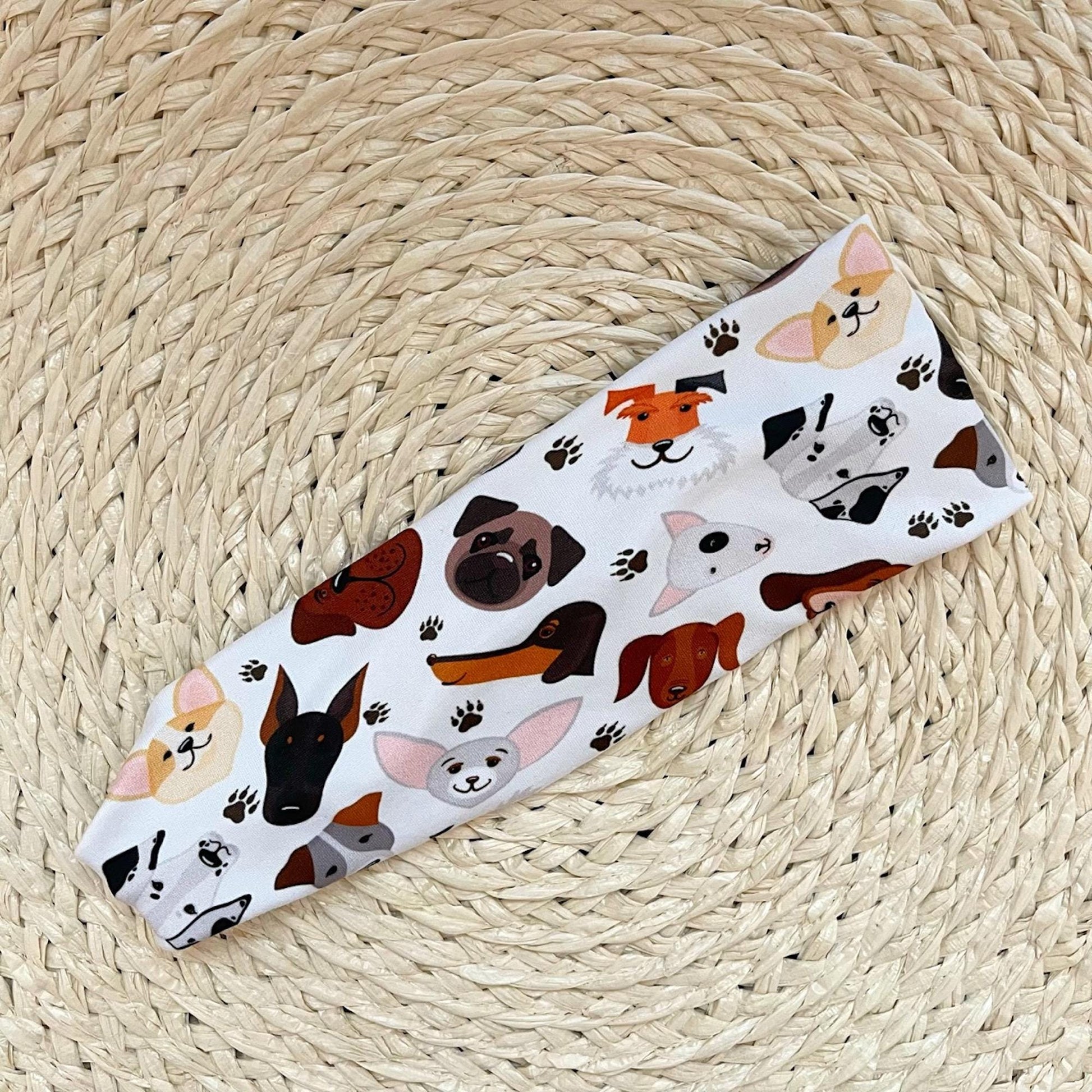 Flat, stretchy headband in white with dog faces print.