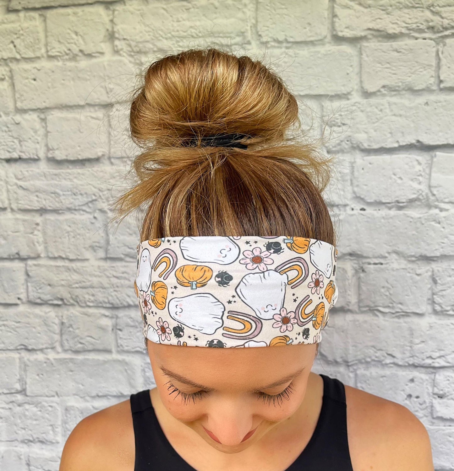 Woman with hair in bun wearing flat, stretchy, halloween theme headband.