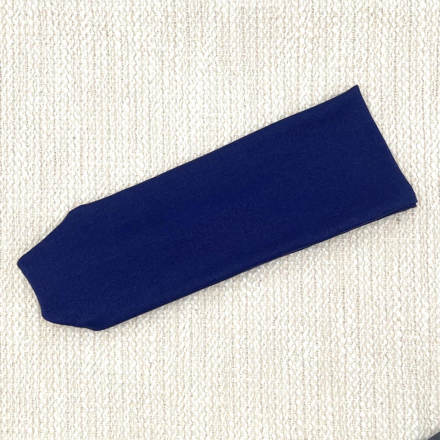 Flat, stretchy headband in dark blue/navy color.