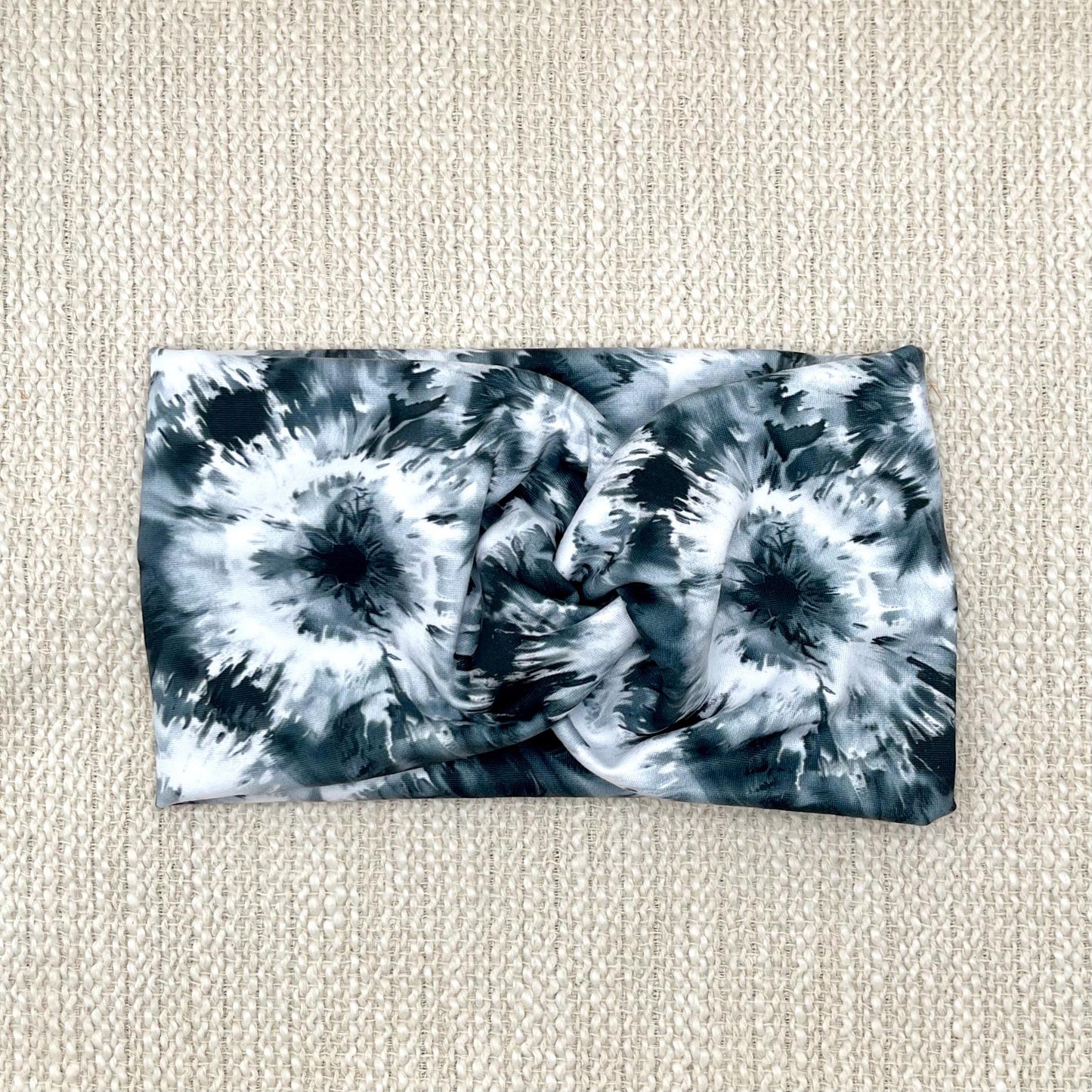 Wide, twisted headband in black, gray, and white tie dye print.
