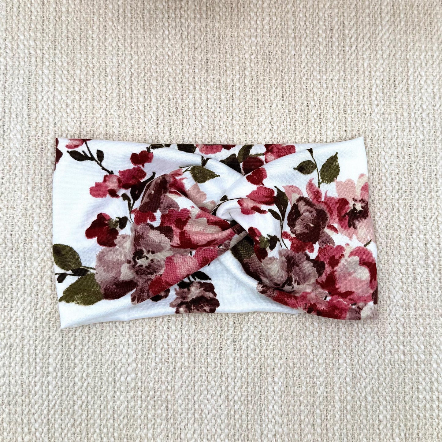 Wide, twisted headband in white with red/burgundy color floral print.
