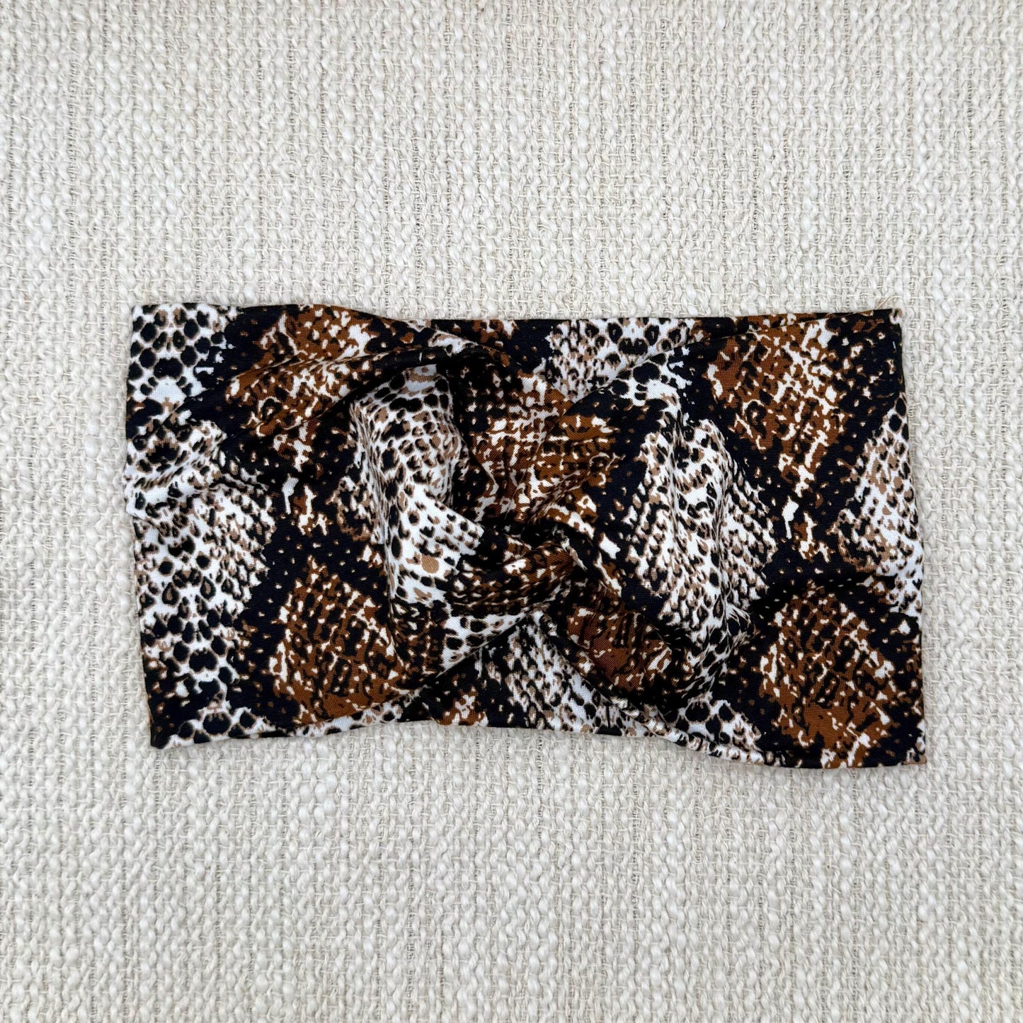 Wide, twisted headband in brown snakeskin print.
