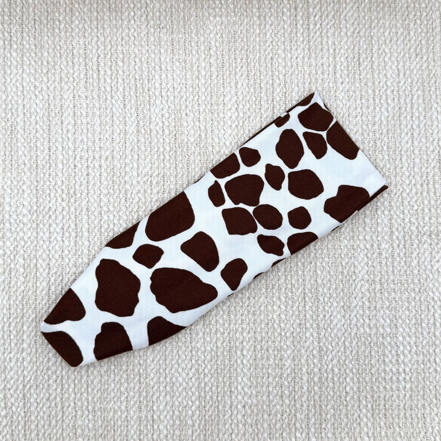 Flat, stretchy headband with giraffe print.