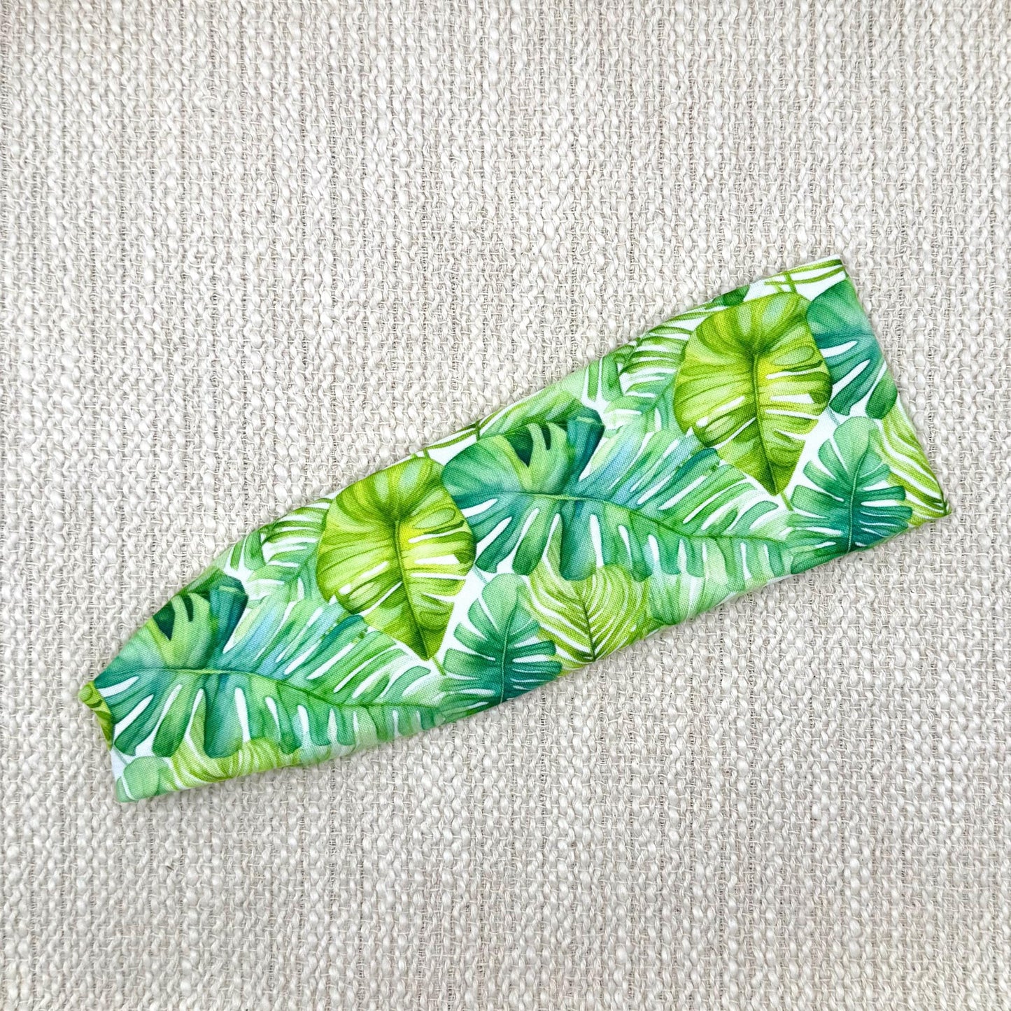 Flat, stretchy headband with palm leaf print.