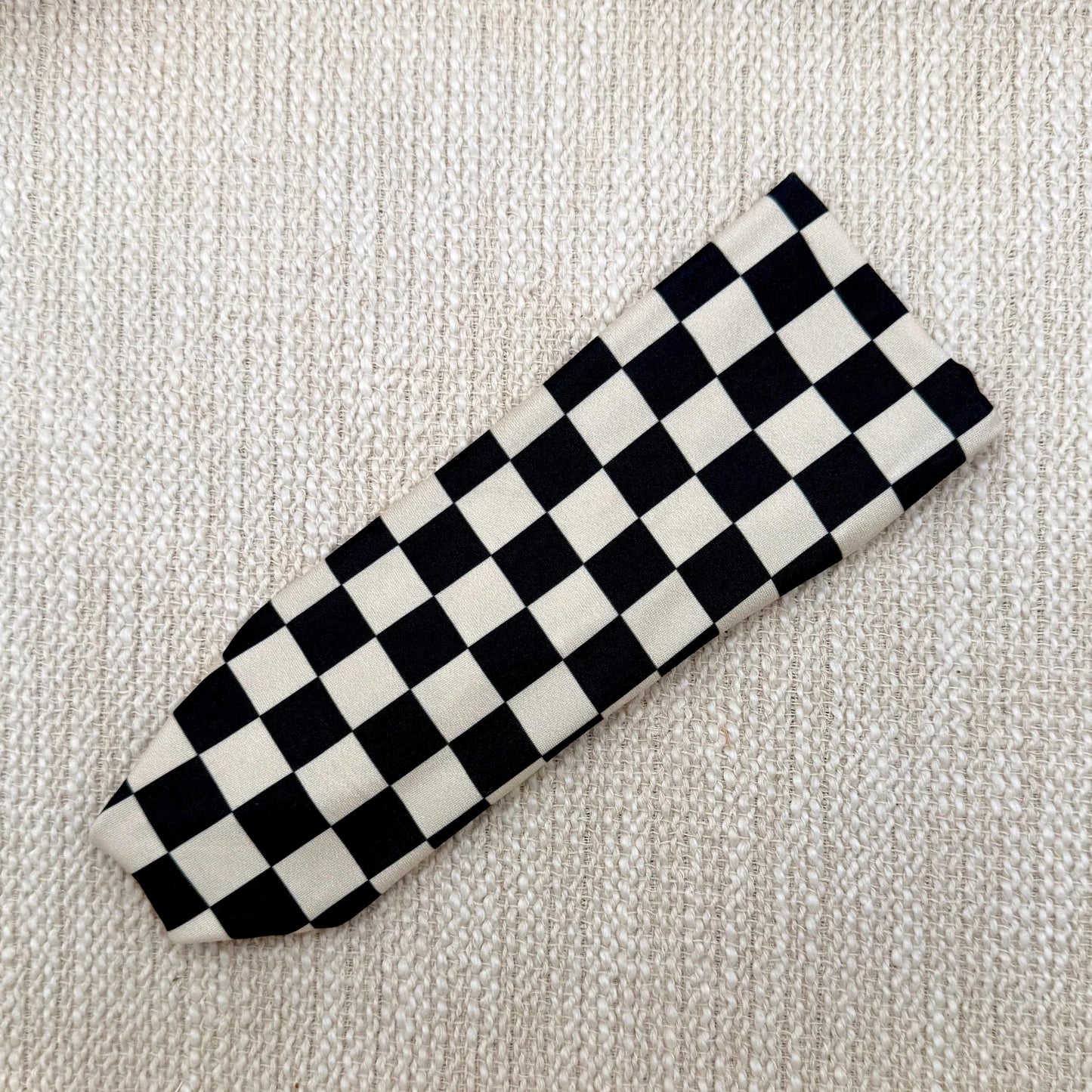 Flat, stretchy headband in black and tan checker print.
