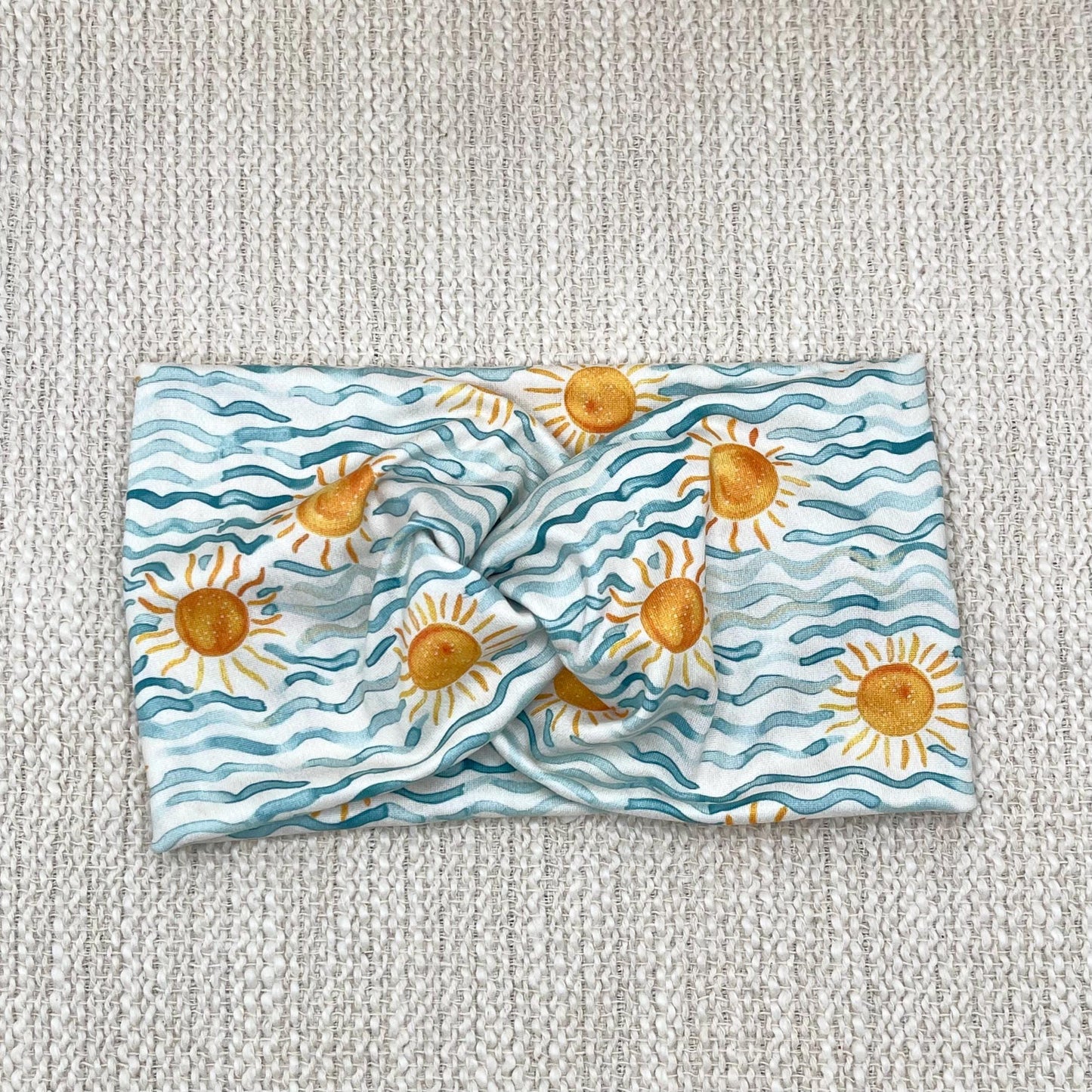 Wide, twisted headband with blue waves and sun print.