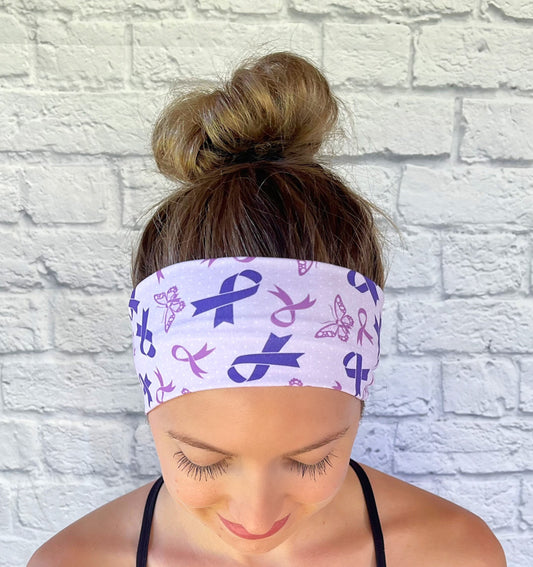 Woman with hair in bun wearing flat, stretchy, purple headband with purple ribbons and butterflies.