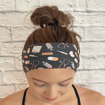 Woman wearing charcoal gray headband with medical theme print.