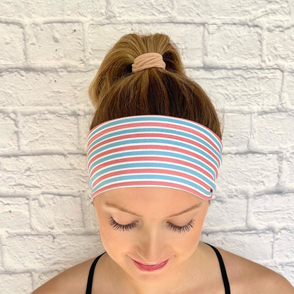 Woman wearing flat, stretchy headband with pink, blue, and white striped print.