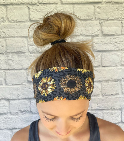 Woman with hair in bun wearing stretchy, black headband with sunflower and leopard print.