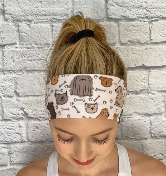 Woman with hair in ponytail wearing light brown, stretchy headband with dog print.