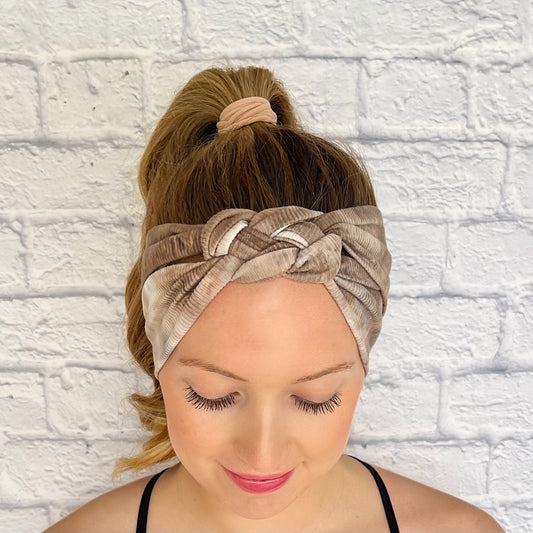 Woman with hair in curled ponytail wearing brown ribbed tie dye sailor knot headband.