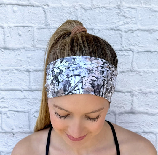 Woman with hair in ponytail wearing flat, stretchy headband with gray and brown camo print.