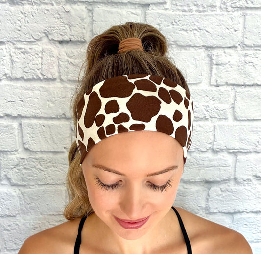 Woman with hair in ponytail wearing flat, stretchy headband with giraffe print.