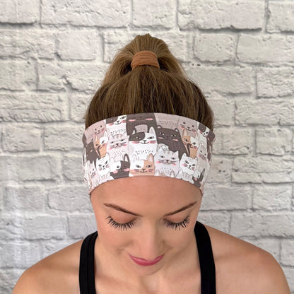 Woman with hair in bun wearing flat, stretchy headband with gray and tan cat print.