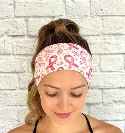 Woman with hair in ponytail wearing flat, stretchy headband with pink ribbon, leaf, and polka dot print.