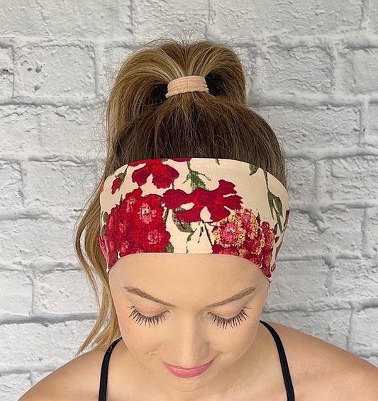 Woman with hair in curled ponytail wearing flat, stretchy, tan headband with rose print.