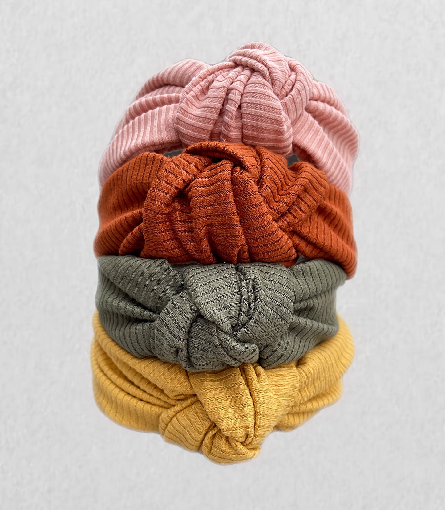 Top knot, hard headbands in varying colors- mustard yellow, light pink, olive green, and burnt orange.