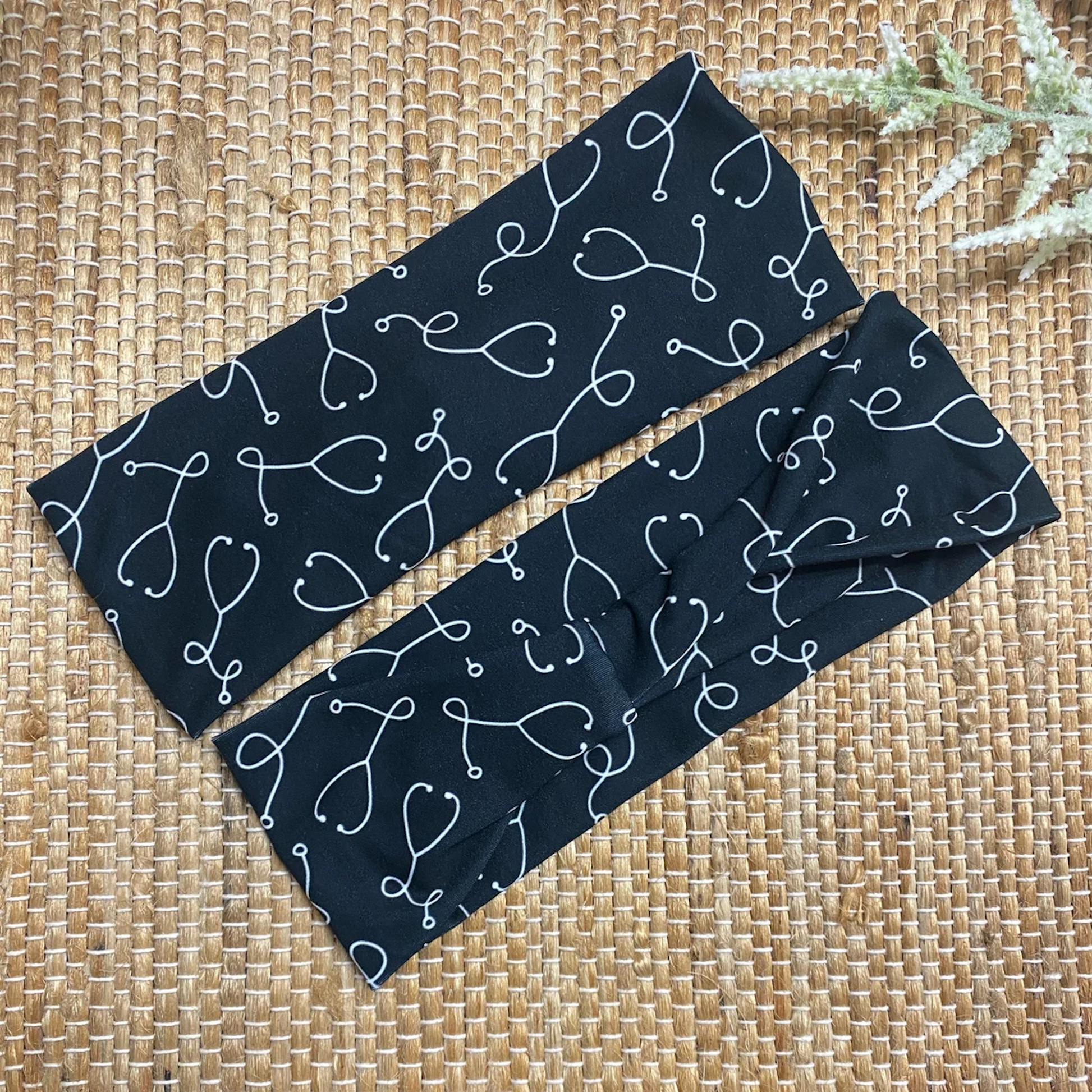 Black, stretchy headband with white stethoscope print.