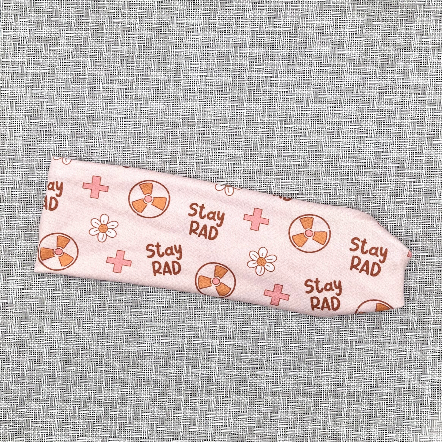 Pink headband with "stay rad" print, radiology theme print, and flowers.