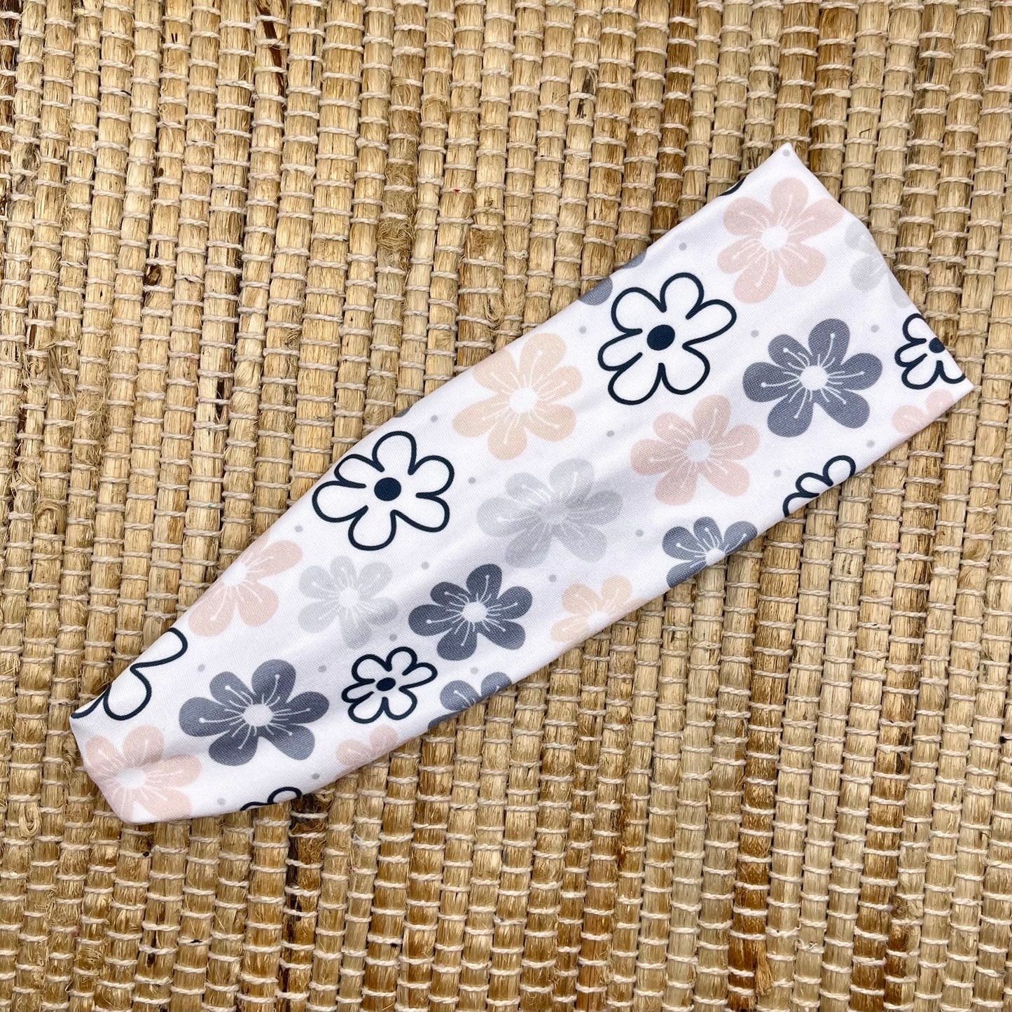 Flat, stretchy headband in white with light pink, gray, and black floral print.