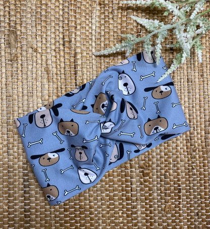 Wide, twisted headband in blue with dog print on a brown background.