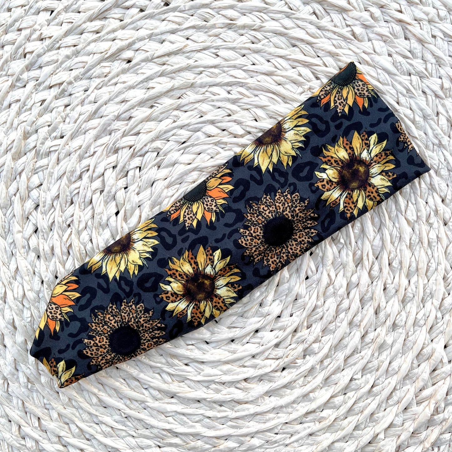 Stretchy, black headband with sunflower and leopard print.