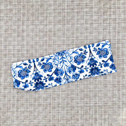 White headband with blue floral print on gray background.