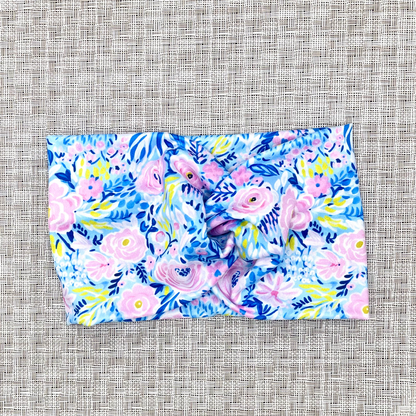 Wide, twisted headband with blue, pink, and green floral print.