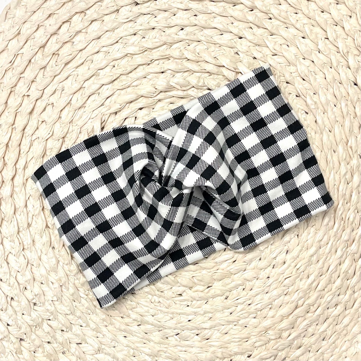 Wide, twisted headband in black and white buffalo plaid print.