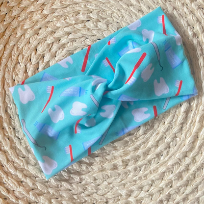 Wide, twisted headband in mint color with dental theme print.