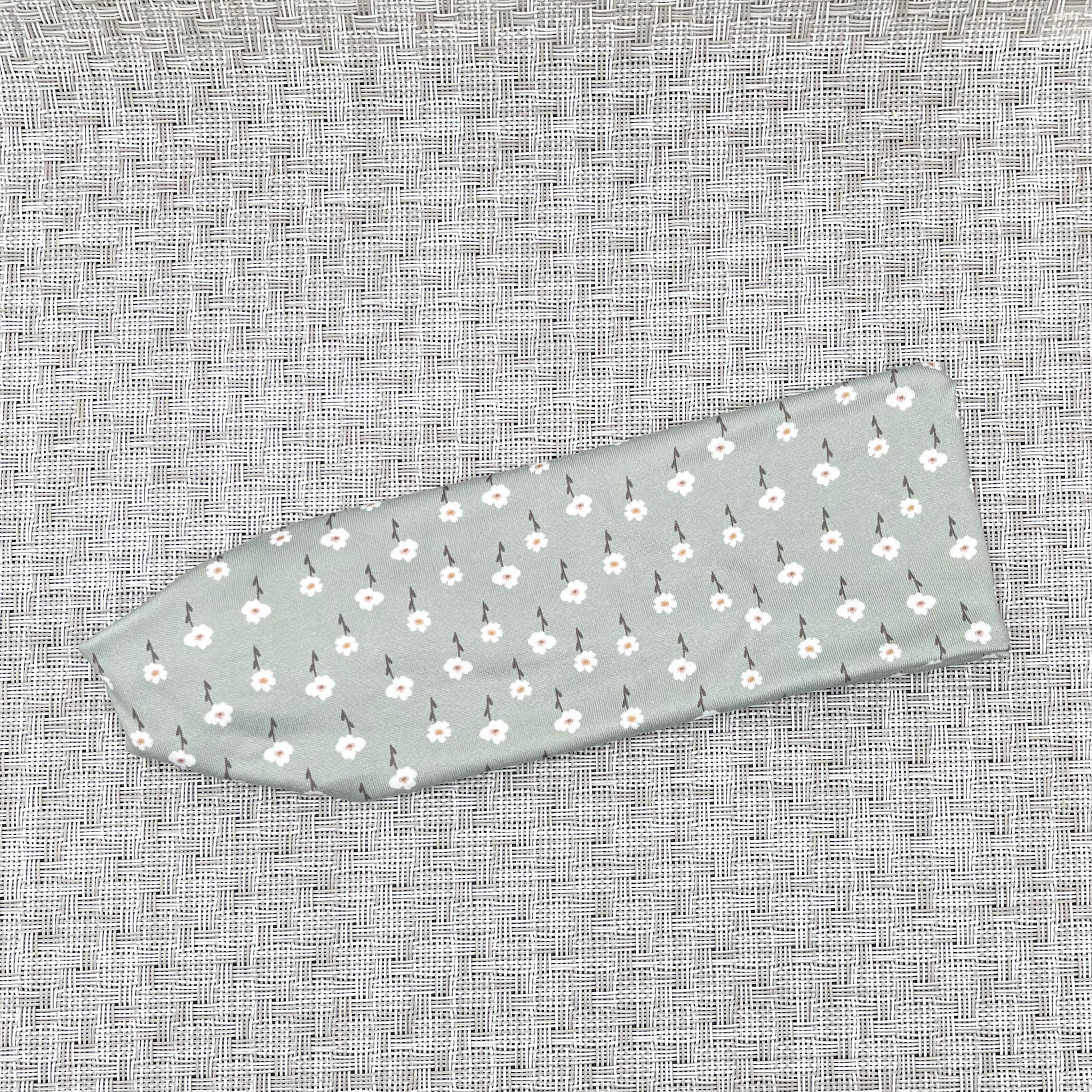 Mint color headband with small white flowers.