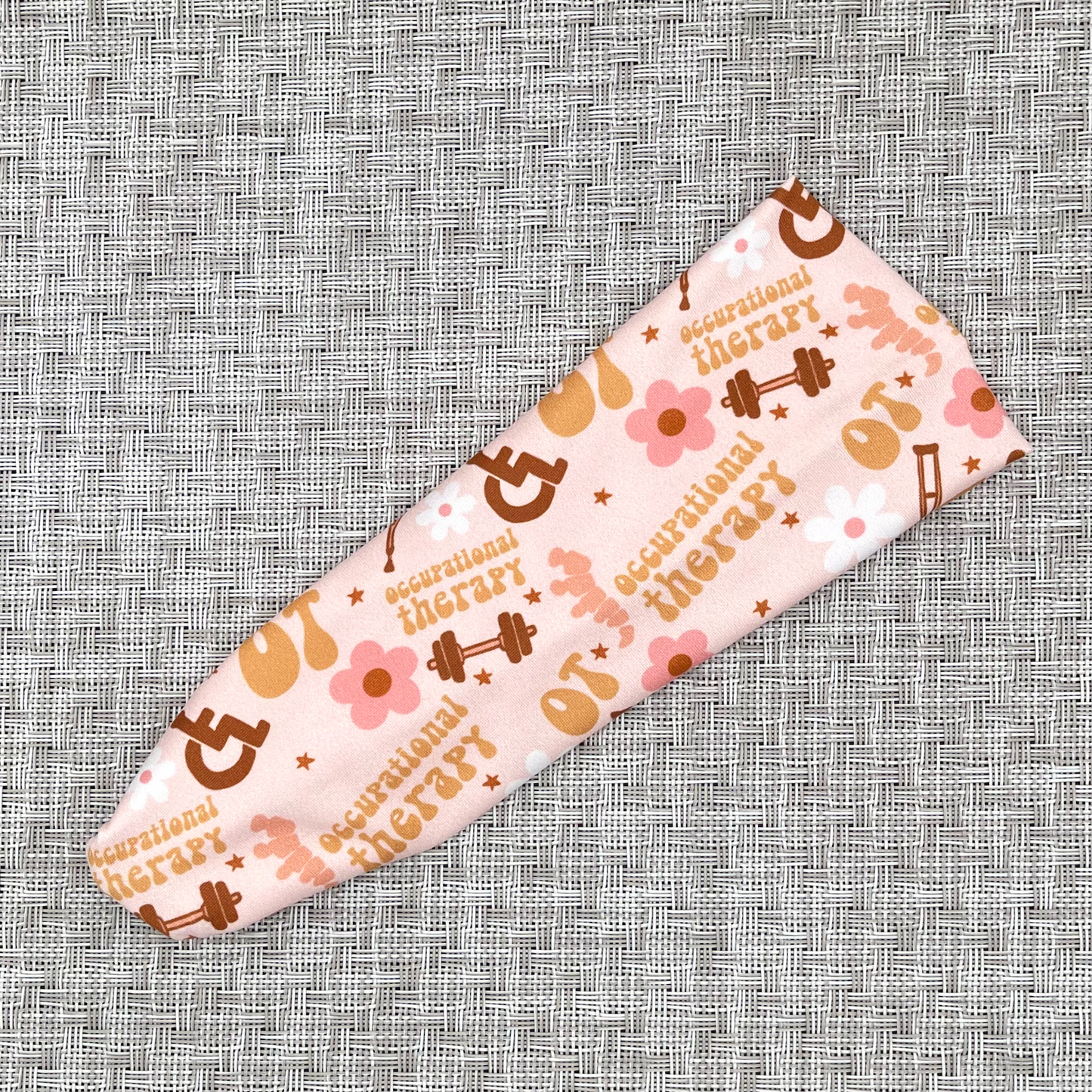 Pink headband with print- OT, occupational therapy with flowers, crutches, wheelchairs, and weights.