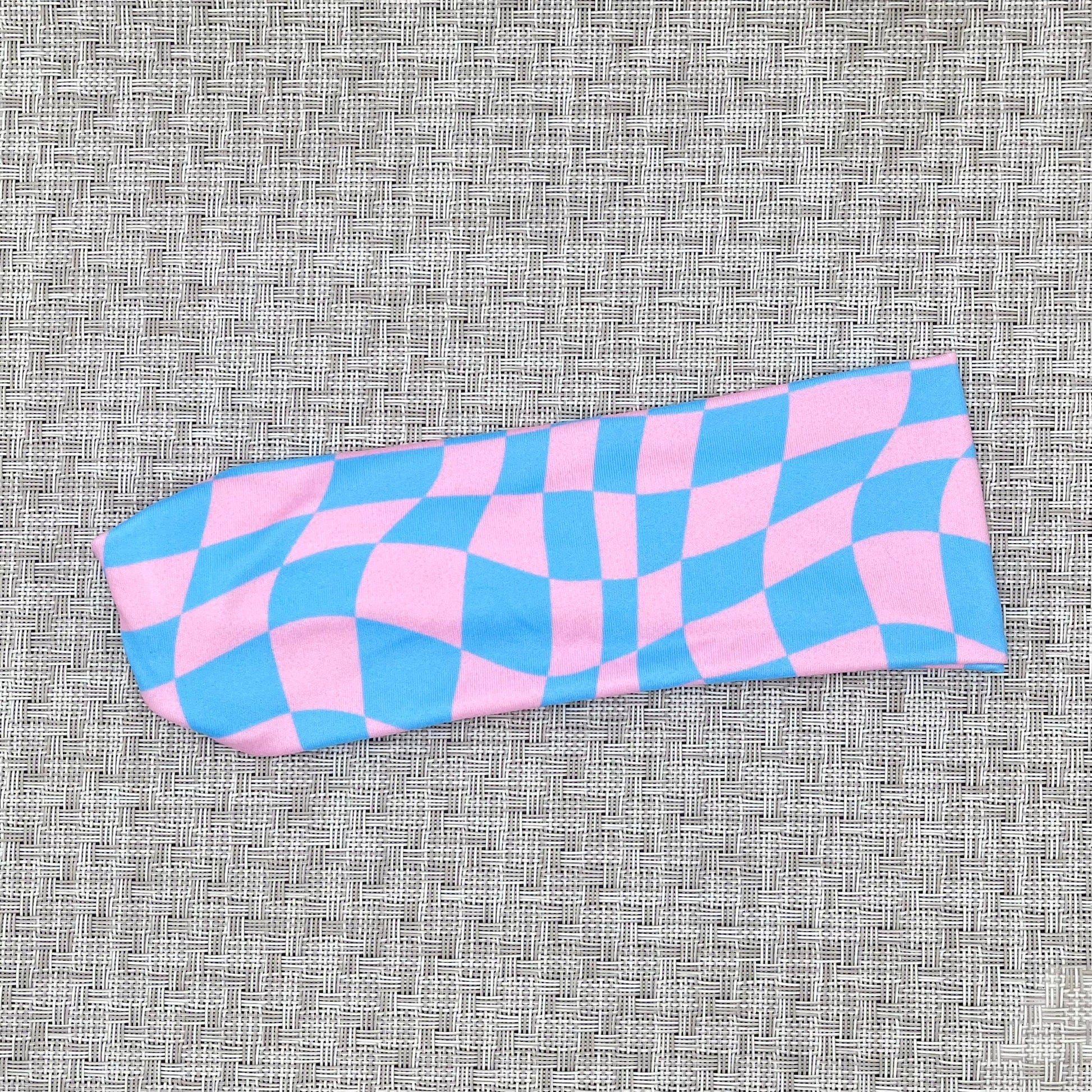 Pink and blue checkered headband on a textured gray background