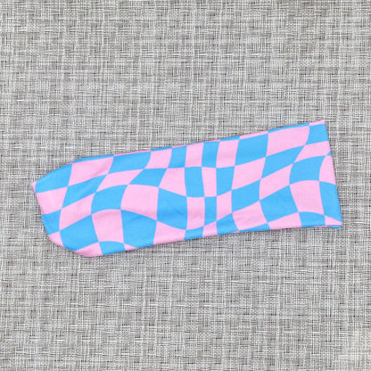 Pink and blue checkered headband on a textured gray background